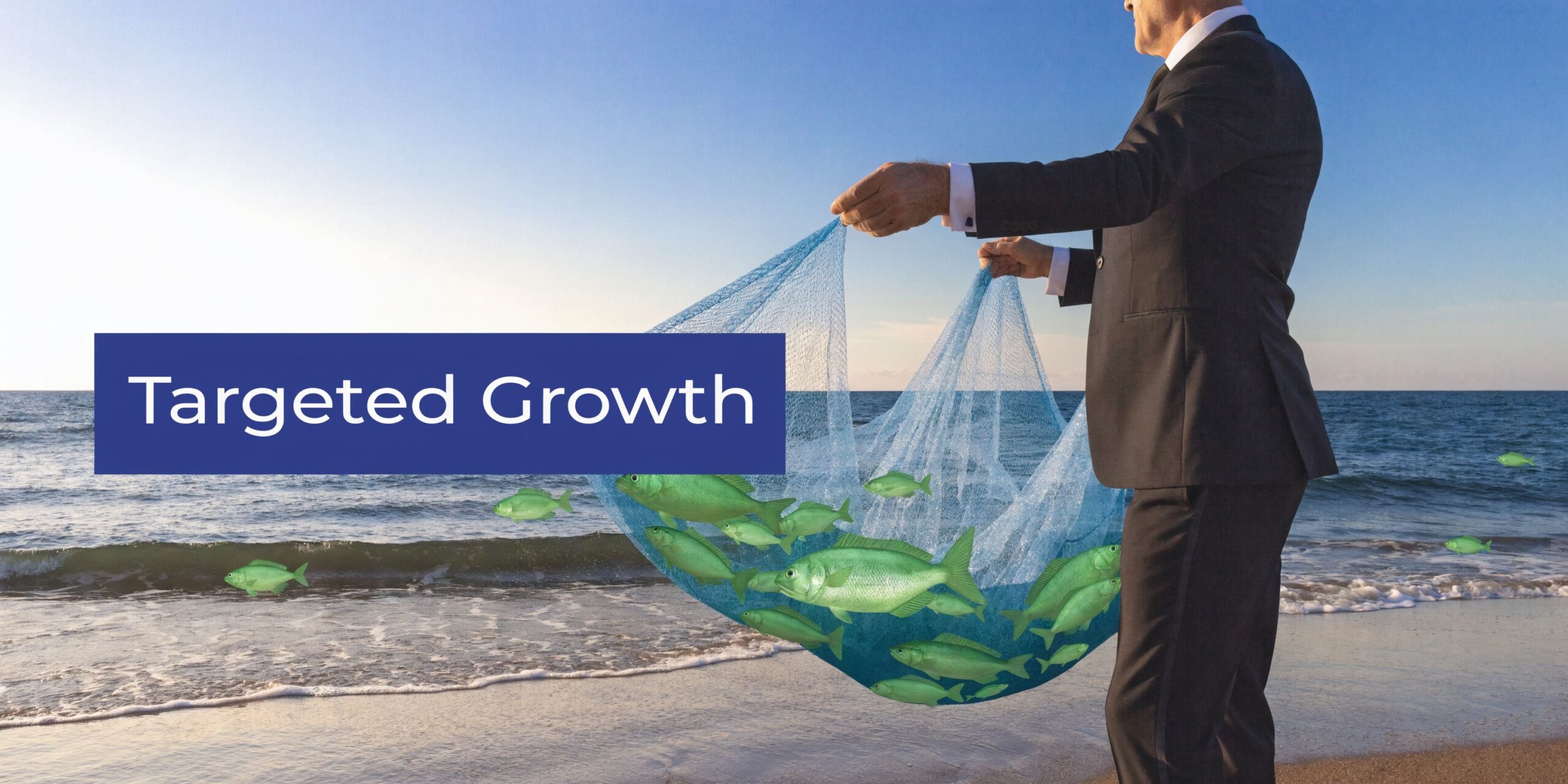 A businessman in a suit standing on the beach catching green fish in a large blue net.