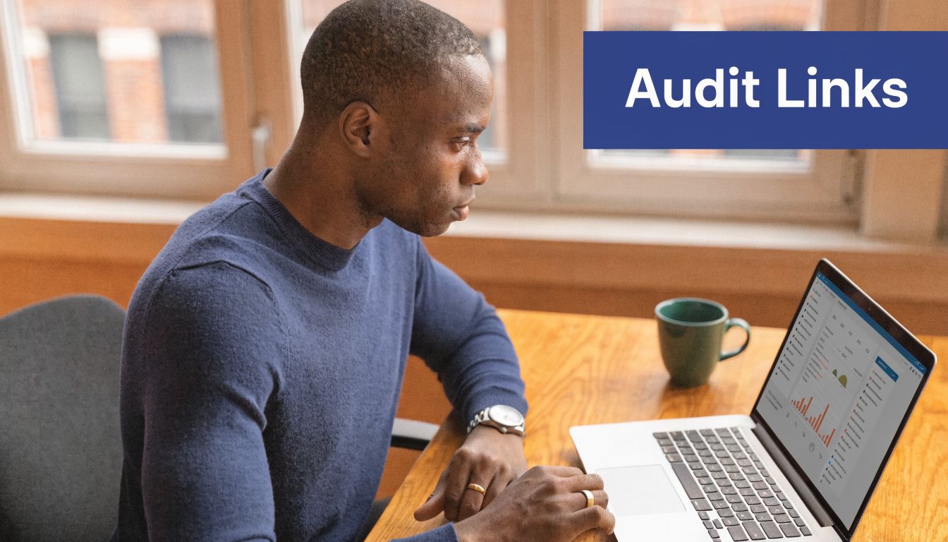 A professional man sitting at a desk and reviewing backlink audit data on his laptop screen.