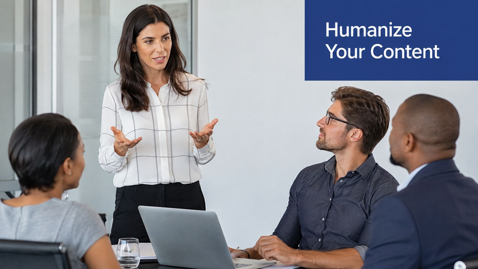 A professional woman presenting to a small diverse group of colleagues in a bright office meeting room.